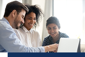 Three employees looking at screen and smiling.